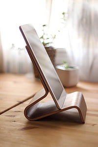 white iPad on brown wooden stand thumbnail