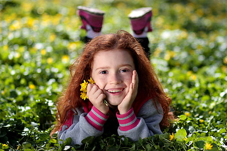 girl lying on green grass field thumbnail