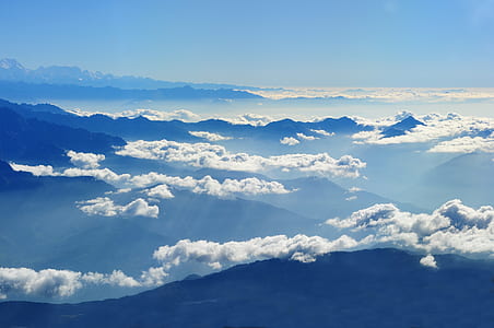 Scenic View of Clouds over Mountains Against Blue Sky thumbnail