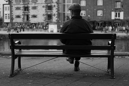 man sitting on bench front of building thumbnail