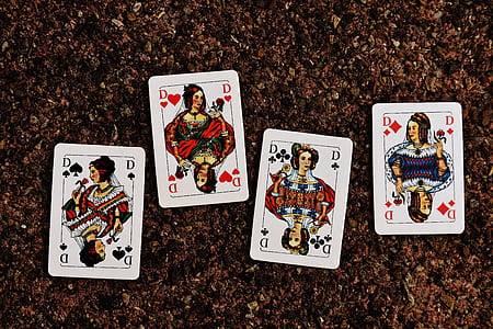 four D playing cards on brown surface thumbnail