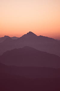 silhouette of mountains under orange sunset thumbnail