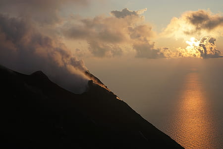 silhouette of mountain under cirrus clouds in a distance of sea thumbnail