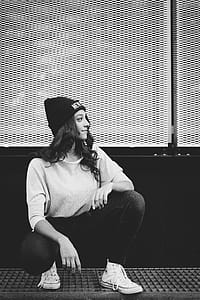 Grayscale Photography Of Woman Sitting Near Wall thumbnail
