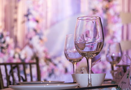 half-full clear wing glass near white ceramic plate and white bowl in table thumbnail