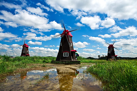 three brown-and-red windmills photo during daytime thumbnail
