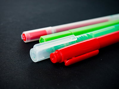 four assorted-color pens on black surface thumbnail