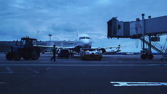 man walking beside white airliner thumbnail