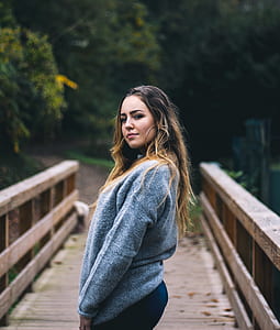 selective focus photography of woman standing on foot bridge thumbnail