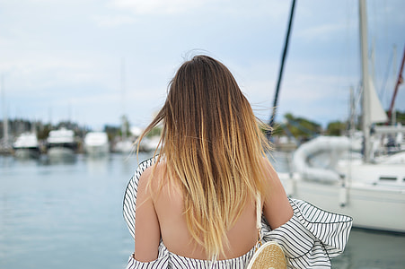woman facing body of water near yacht thumbnail