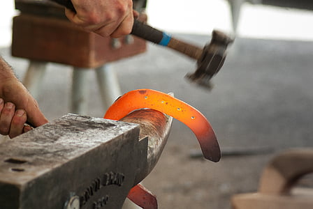 person holding glowing metal on anvil thumbnail