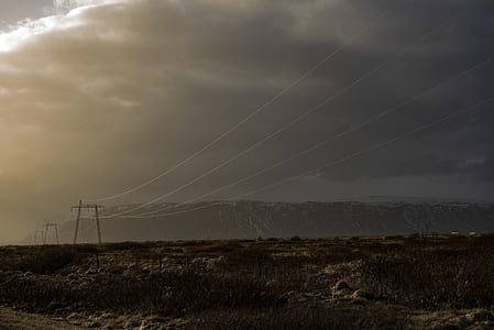utility towers with wires under clouds thumbnail