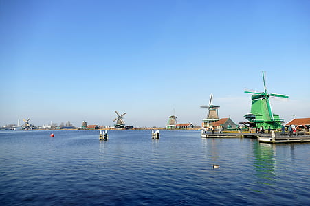 green and brown windmills under blue sky at daytime thumbnail