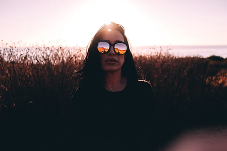woman standing in grass field wearing sunglasses thumbnail
