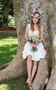 woman in white sleeveless dress posing for photo thumbnail