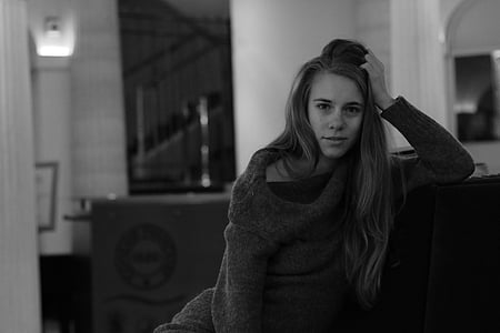 grayscale photo of woman leaning on wall thumbnail