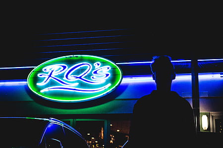 silhouette photography standing beside LED signage thumbnail