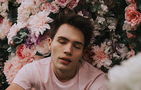 man lying on flowers with close eyes thumbnail