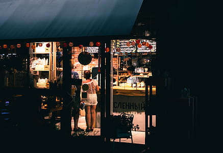 Woman in White Top Mini Dress Standing Near Store Door thumbnail