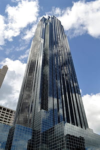 low angle photography of glass high-rise building over blue and cloudy sky at daytime thumbnail