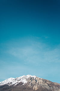 mountain covered with snow under blue sky thumbnail