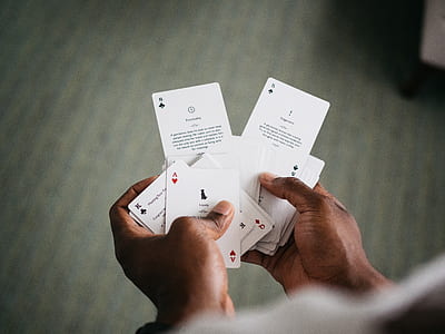 person holding playing cards thumbnail