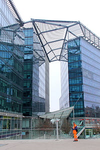 standing man near blue and gray building during daytime thumbnail