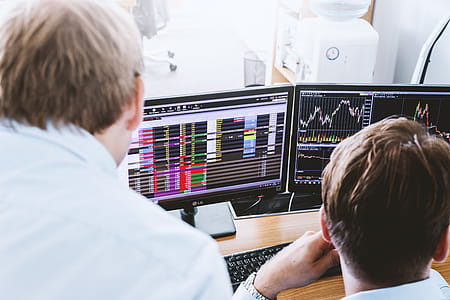 Stock brokers looking at graphs, indexes and numbers on multiple computer screens thumbnail