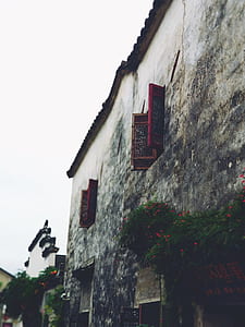 two opened red wooden windows during daytime thumbnail