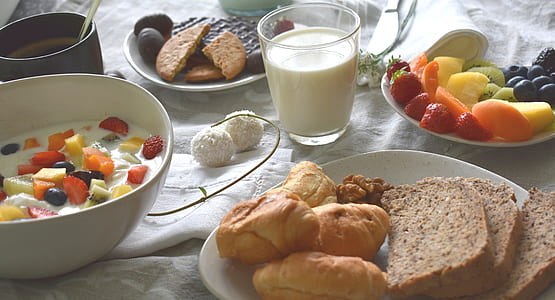 milk in drinking glass beside plate of cooked foods thumbnail
