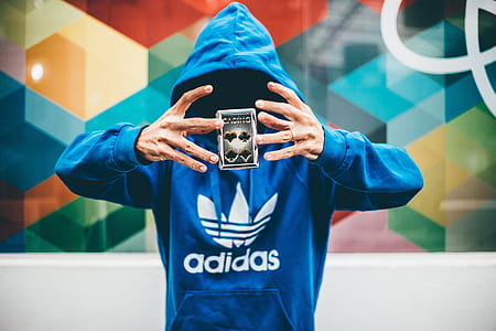 person wearing blue adidas pullover hoodie levitating playing card thumbnail
