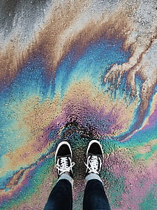 person standing on ground with oil slick thumbnail