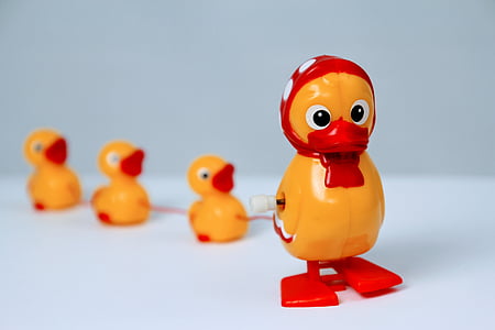 yellow and red plastic duck with 3 ducklings plastic toy on white surface thumbnail