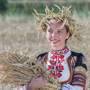 woman looking sideways while holding wheat thumbnail