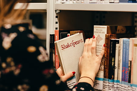 macro shot photography of woman in black top holding Shakespeare book thumbnail