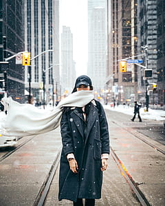 woman standing in the middle of railway surrounded by buildings thumbnail