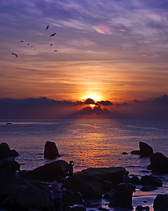 landscape photograph of rock in body of water during sunset thumbnail