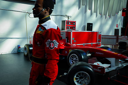 man wearing red and white overalls beside F1 car thumbnail