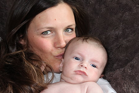 woman with brown hair carrying a baby thumbnail