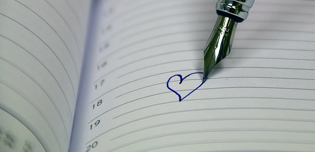 silver fountain pen drew a heart in white ruled paper thumbnail