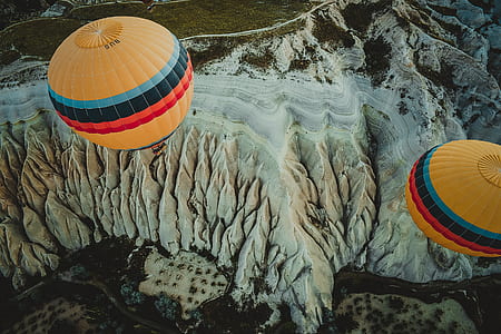 yellow-blue-and-red hot air balloon flying on top of mountain thumbnail