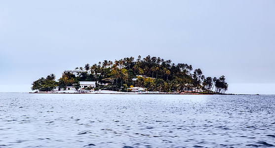 houses built on island under clear blue sky thumbnail