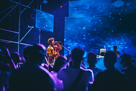 man in orange jacket singing on stage thumbnail