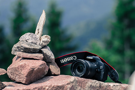 DSLR camera resting on rocks in outdoor setting thumbnail