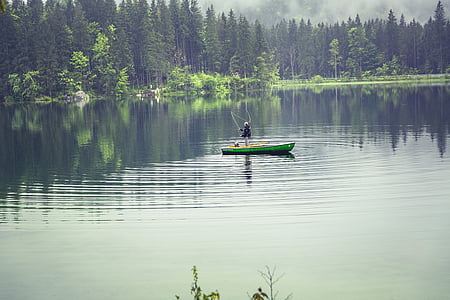 man on green canoe in the middle of the lake thumbnail