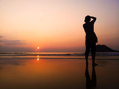 silhouette of person standing on seashore thumbnail