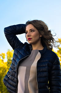 woman in black bubble jacket holding her head thumbnail