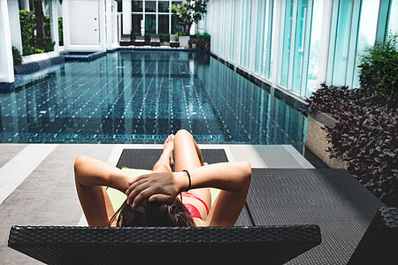 woman wearing red bikini laying on black lounge bed thumbnail