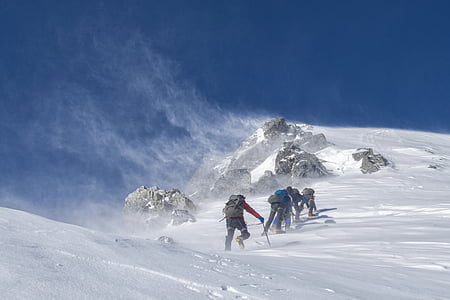 group of people climbing mountain covered in snow at daytime thumbnail