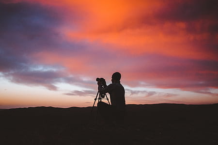 silhouette photo of man using camera with stand thumbnail